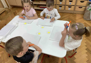 Dzieci przy stoliku z koszulkami.