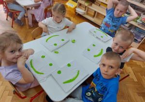 Zadowolone z siebie przedszkolaki pokazują efekty swojej pracy