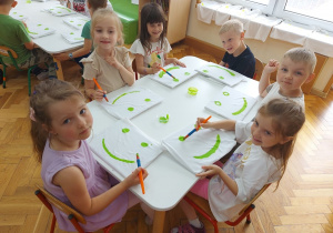 Zadowolone z siebie przedszkolaki pokazują efekty swojej pracy