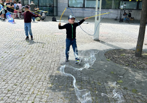Chłopiec puszcza duże bańki mydlane.
