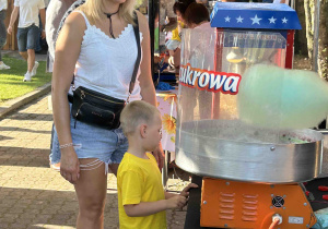 Chłopiec czeka z mamą na watę cukrową.