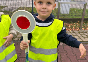 Chłopiec trzyma lizak policyjny.