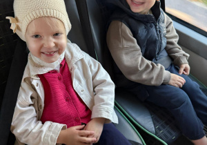 Uśmiechnięte dzieci w autobusie.