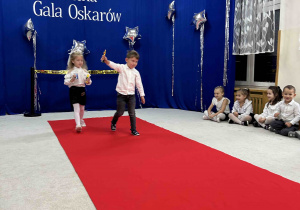 Dziewczynka i chłopiec prezentują Oscara.