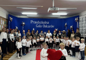 Dziewczynka i chłopiec prezentują duże pluszowe serce.