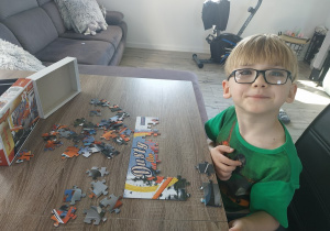 Chłopiec układa puzzle