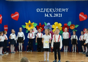 CHłopiec i dziewczynka występuja przed publicznością
