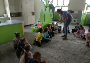 Pani rozdaje dzieciom bilety do zadań