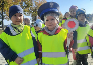 Dzieci w policyjnej czapce i z tarczą do kierowania ruchem drogowym