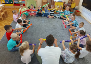 Dzieci wykonują zadania z rurkami.